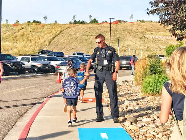 Photo of police officer greeting student