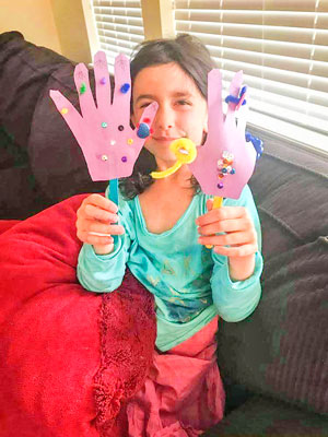 Photo of first grader shows her completed hand puppets