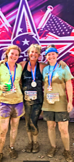 Photo of Ronda Gutierrez daughters run a mud obstacle course race together.