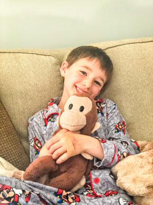 Reid Berry cuddling Curious George.