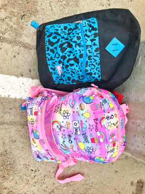 Photo of backpacks filled with clothes, socks, towels, and more
