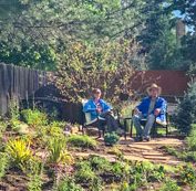 Photo of Leigh and Eric Houston relax in front lawn that is xeriscaped.
