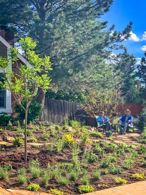 Photo of Leigh and Eric Houston relax in front lawn that is xeriscaped.