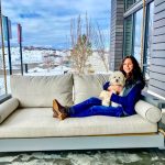 Photo of Dana Jevarjian and her dog, Benji, on the porch swing outside The Exchange Coffee + Conversation