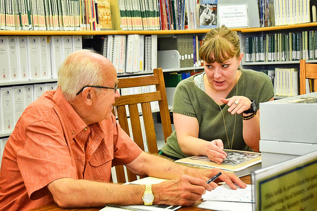 Photo of Joe Gschwendtner works with Douglas County Libraries Archivist Alyssa Carver on historical research.