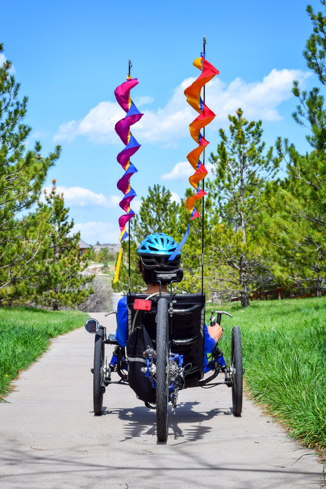 Photo of Carol Gransee and her flags on recumbant bike.