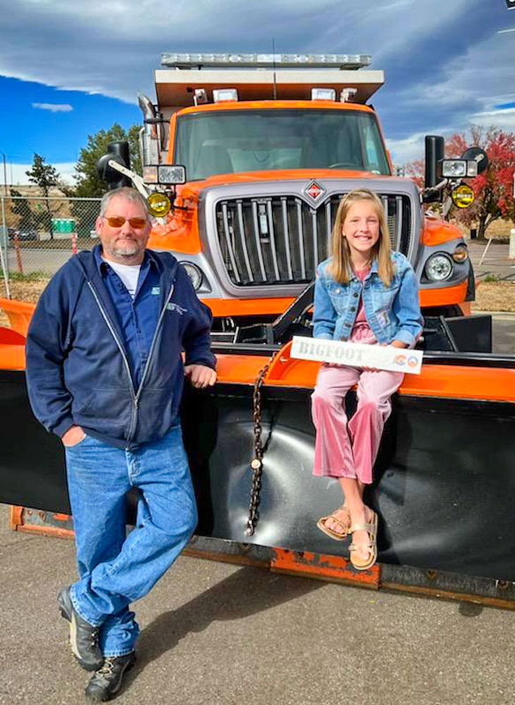 Photo of Timber Trail Elementary fifth grade student Leyna Sanford sits atop a snowplow