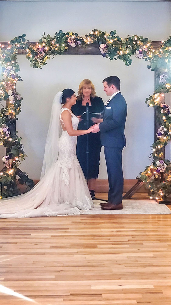 Photo of RHMS teacher Judi Holst officiating the wedding of two of her former students, Alana Rainosek and Ethan Myers,