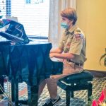 Photo of Russell Christensen plays the piano at Legacy Village