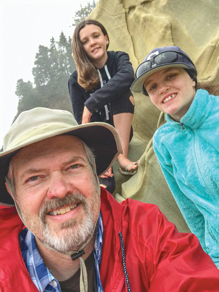 Photo of Einar Jensen with his twin daughters Tabor (left) and Kali (right).