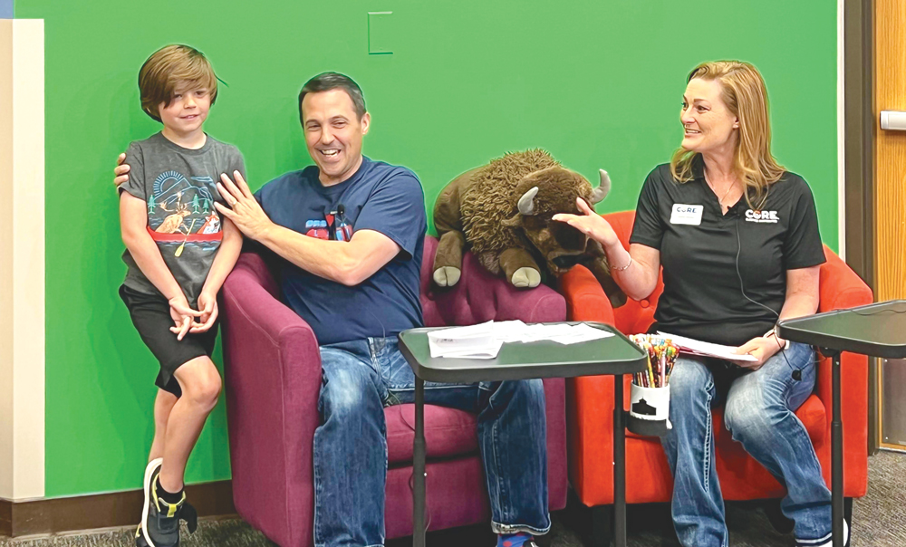 Photo of Buffalo Ridge Elementary art teacher, Tim Ryckman, congratulates Ethan L.