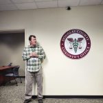 photo of man standing next to coroners office