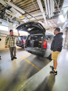 photo of men next to open car