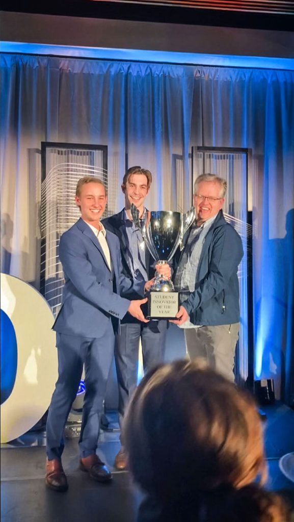 photo of three men holding trophy