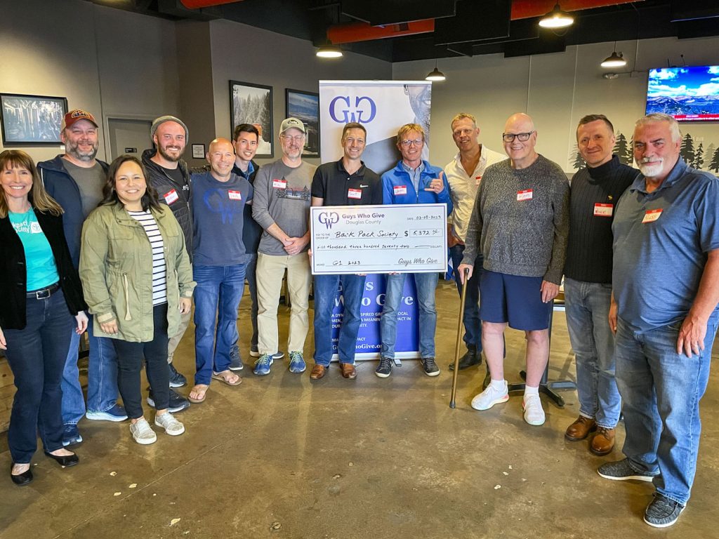 photo of group of people holding check