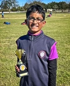 photo of young boy holding cricket trophy
