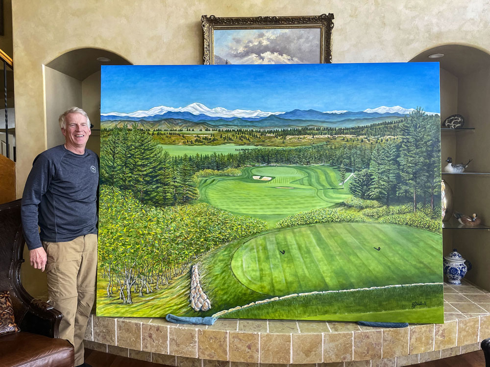 man standing next to large painting