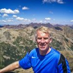 man standing in front of mountain range