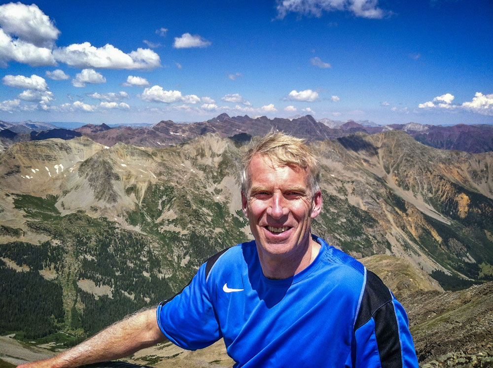 man standing in front of mountain range