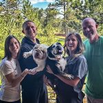 family holding their dogs up
