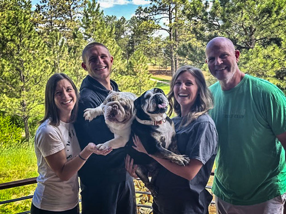 family holding their dogs up