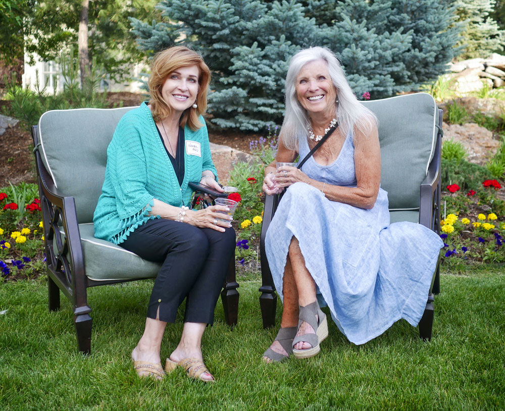 two ladies sitting in chairs in garden