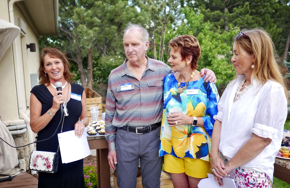 lady speaking with three other people in image