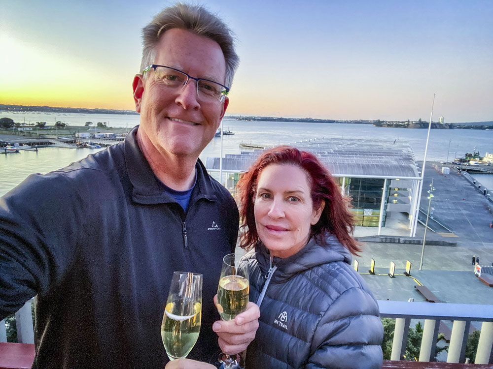 couple standing with champagne glasses outside