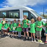 group of students outside of a van