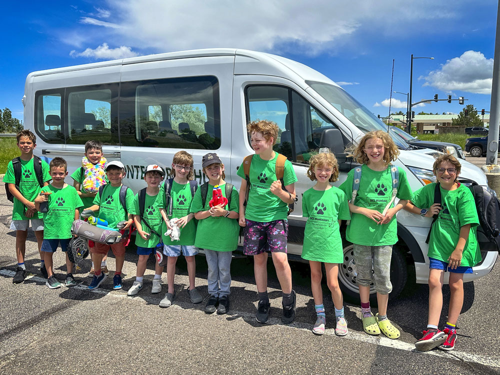 group of students outside of a van