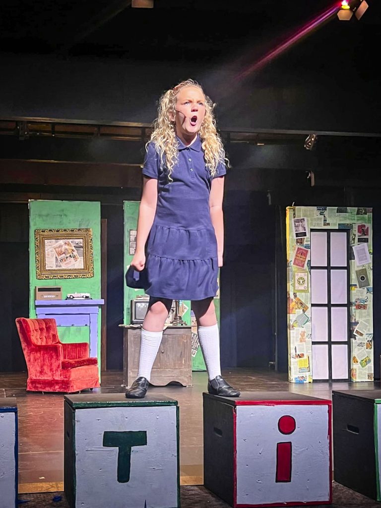 girl standing on stage singing