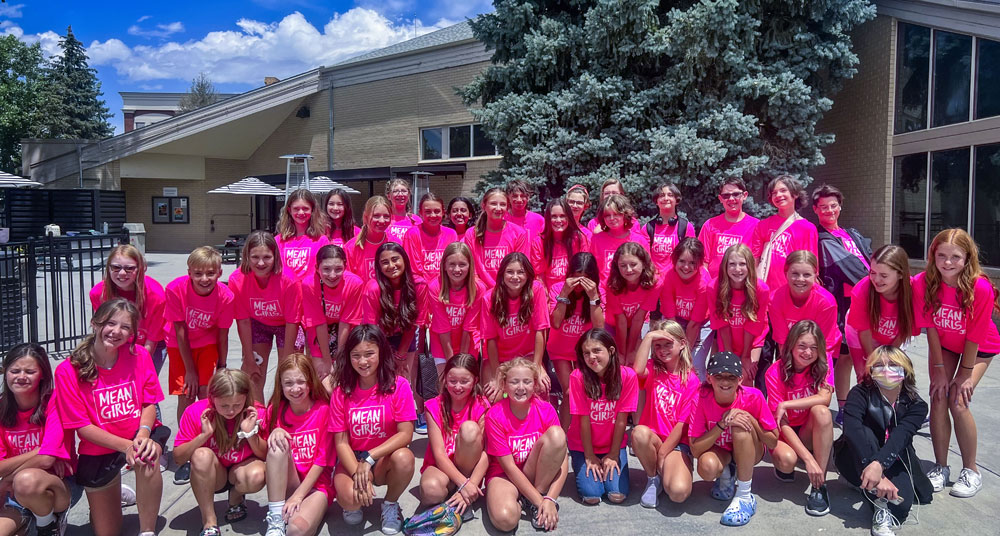 large group of students outside wearing pink shirts