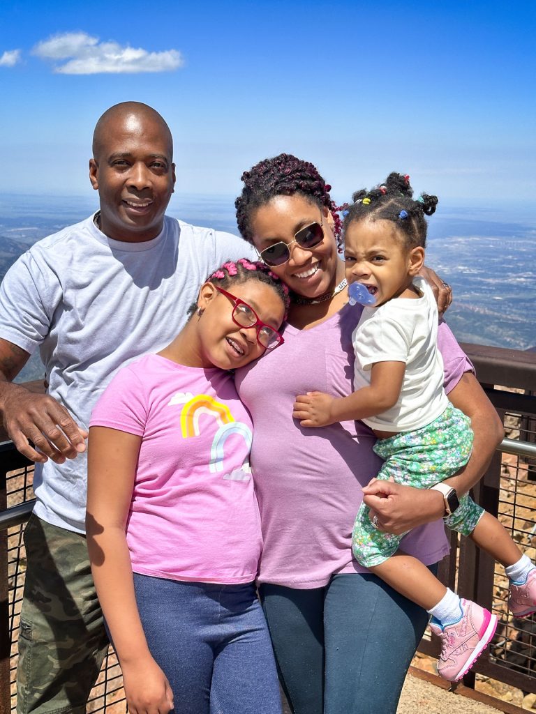 family posing at top of mountain