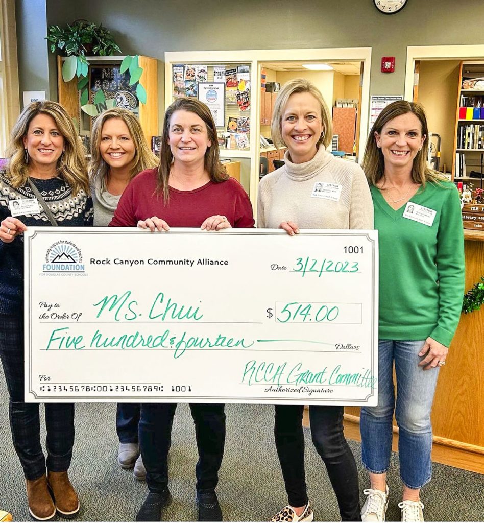 group of ladies holding charity check