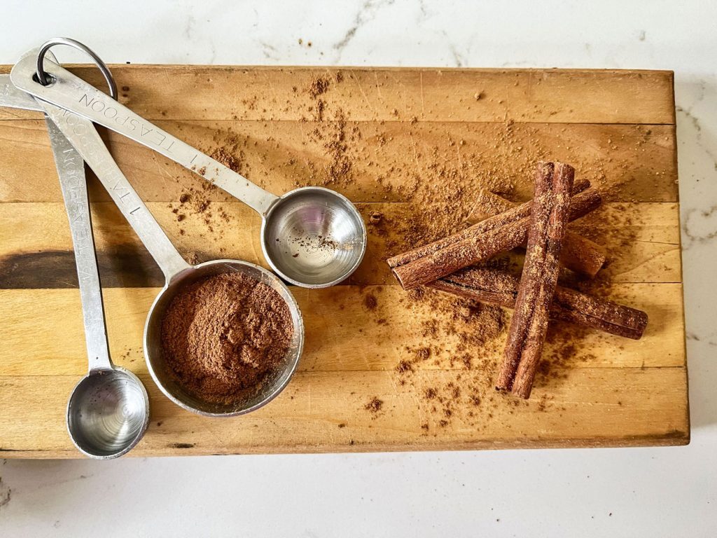 spoons and cinnamon sticks on wood tray