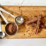 spoons and cinnamon sticks on wood tray