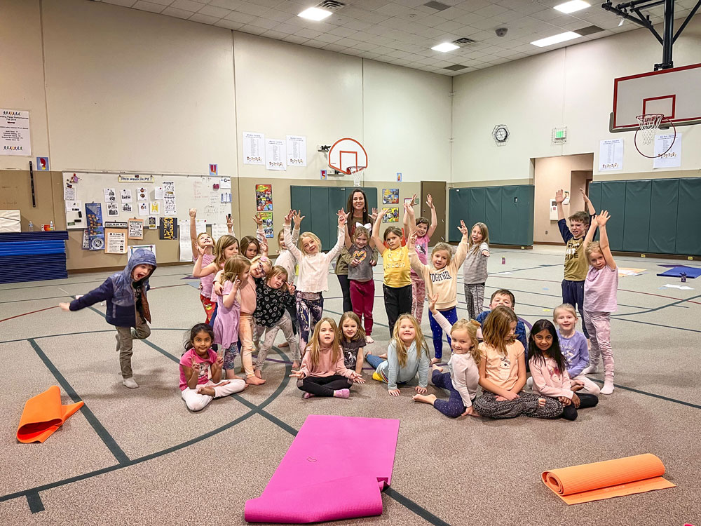 group of kids and teacher in gym with yoga mats