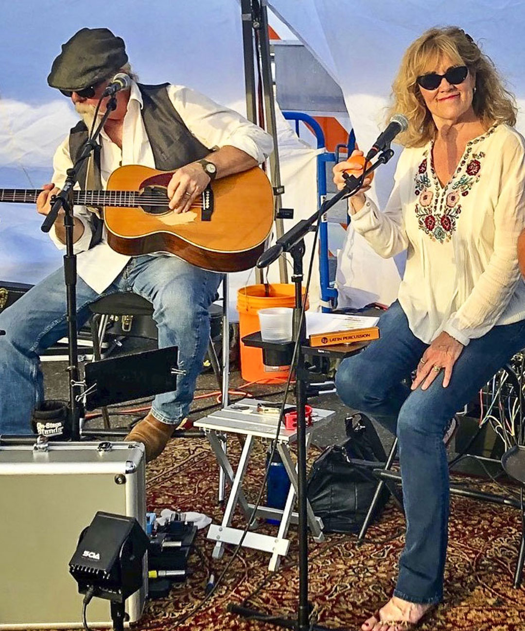 couple on stage singing and playing guitar