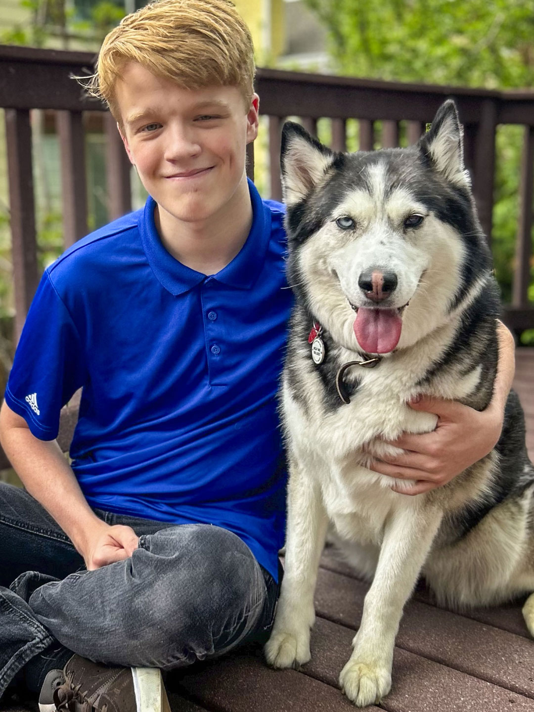 boy and dog outside next to each other