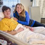 son in hospital bed with mom next to him