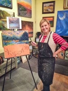 woman next to painting in gallery