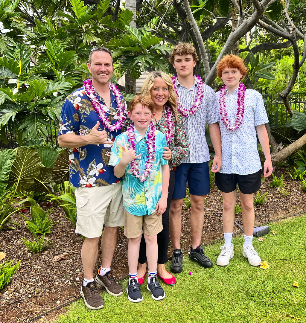 family posed for photo wearing leis