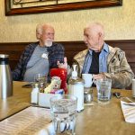 two men talking while at a restaurant