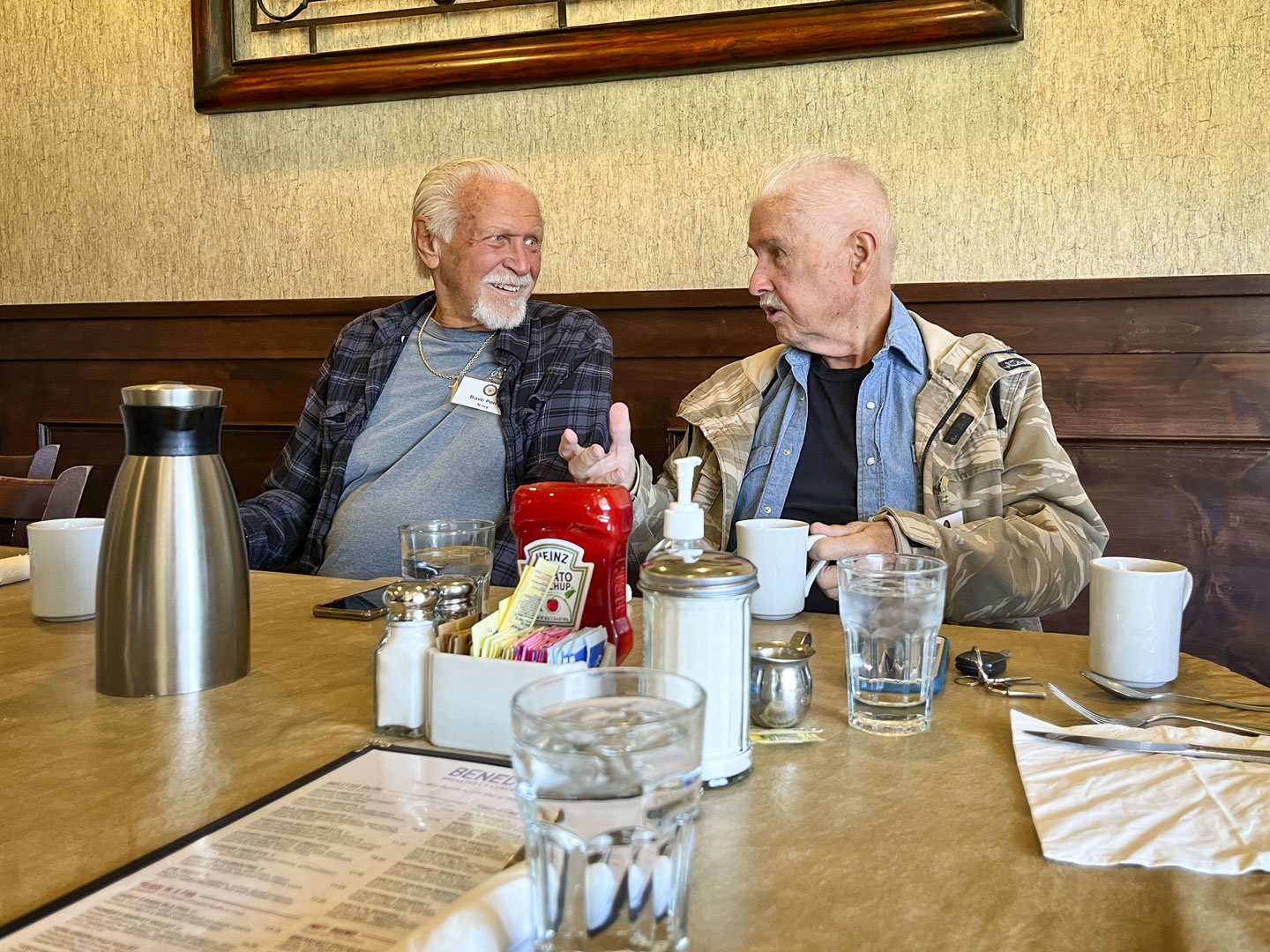 two men talking while at a restaurant