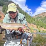 person holding large fish in lake