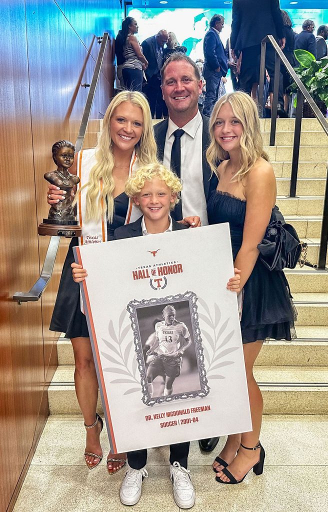 four people in formal wear holding honors