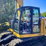 young girl outside in construction machine