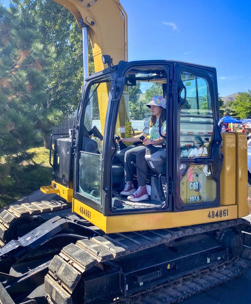 young girl outside in construction machine