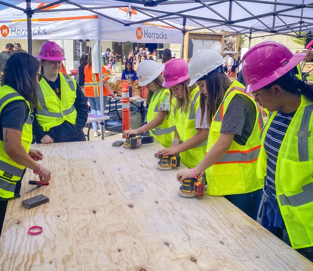 young girls in hard hats and construction vests