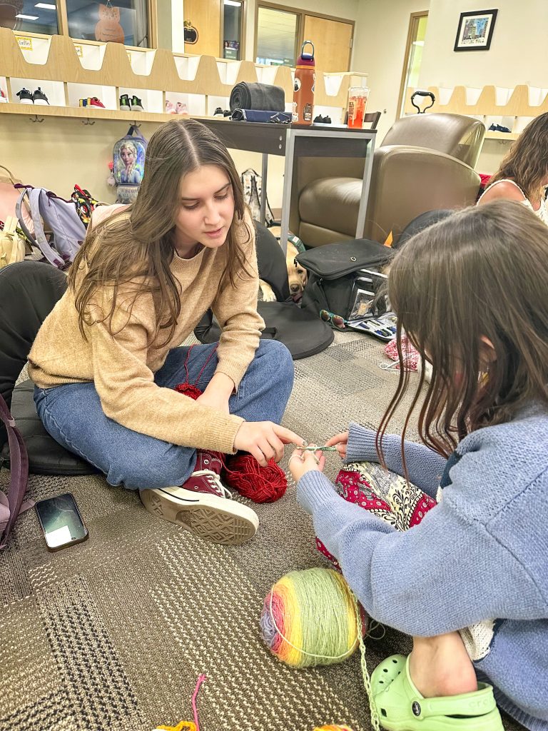 teen and kid holding yarn